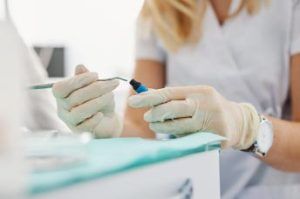 Mujer que llega dentro de la botella de material compuesto con tallador dental